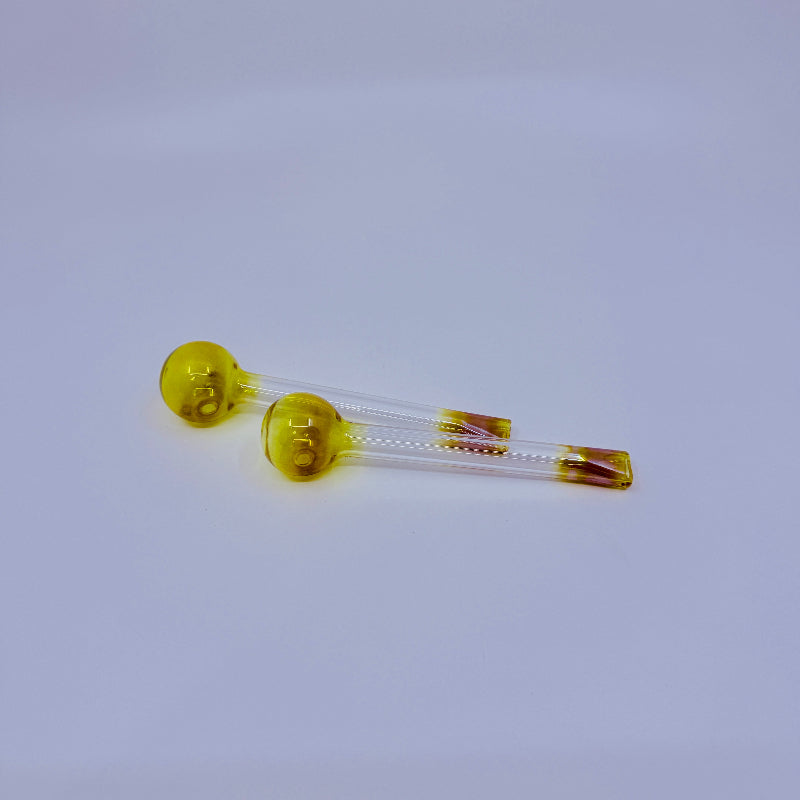 Two yellow glass vials with clear liquid on a light gray background