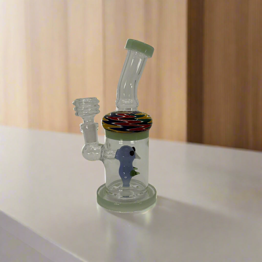 Glass water pipe with colorful base and seahorse design on a white background