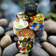 100 mm 4 Part Multi Color Grinder with vibrant graphics and durable design displayed on rocks.