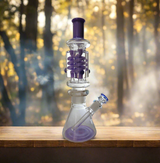 Glycerin bong with triple coils, 14-inch freezable design, on wooden surface in forest setting.