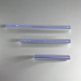 Three clear cylindrical objects on a light purple background