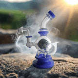 Bent Neck Lollipop Ball Insert Perc Dab Rig 8.5" on rocky surface, emitting vapor, with scenic backdrop.