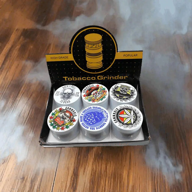 4 Part Heavy Metal White Cannabis Grinder display with assorted designs in box on wooden surface.