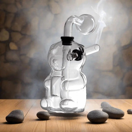 Glass oil burner bubbler pipe on a wooden surface with stone accents and smoke.