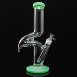 Glass smoking device with green base and accents on a white background