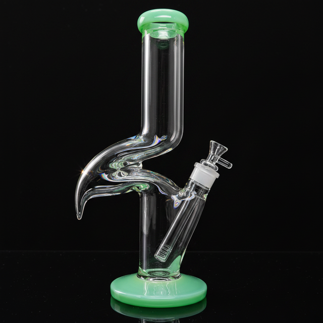 Glass smoking device with green base and accents on a white background