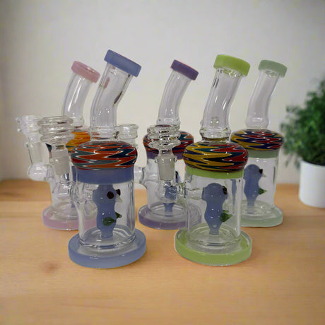 Set of glass smoking accessories with colorful bases on a white background