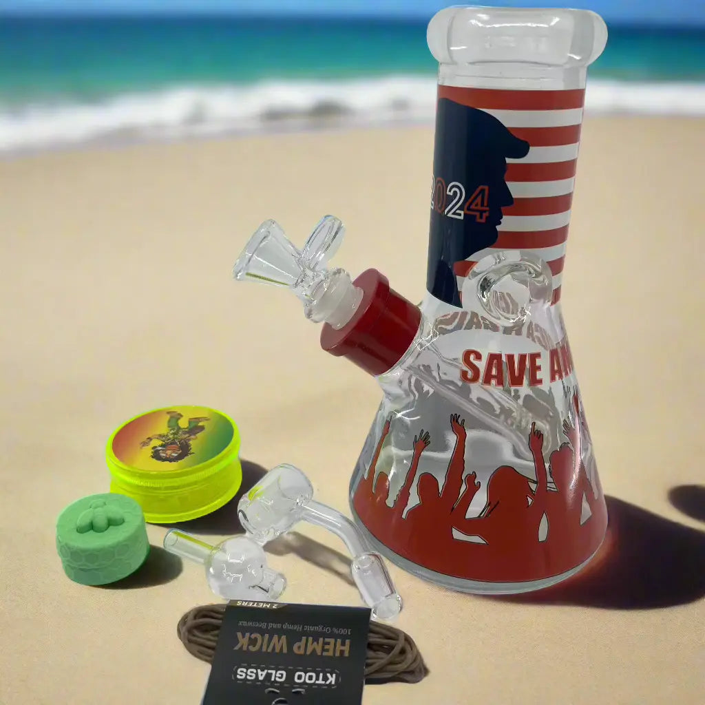 Trump 2024 Bong Box with beach background, featuring an 8-Inch Trump-themed bong, plastic grinder, silicone container, quartz banger, hemp wick, carb cap, downstem, ball & metal dabber.