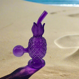 Unique 6-inch glass pineapple-shaped dab rig on sand.