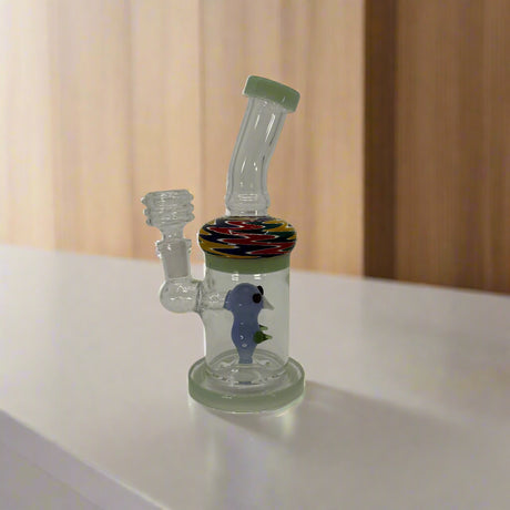 Glass water pipe with colorful base and seahorse design on a white background